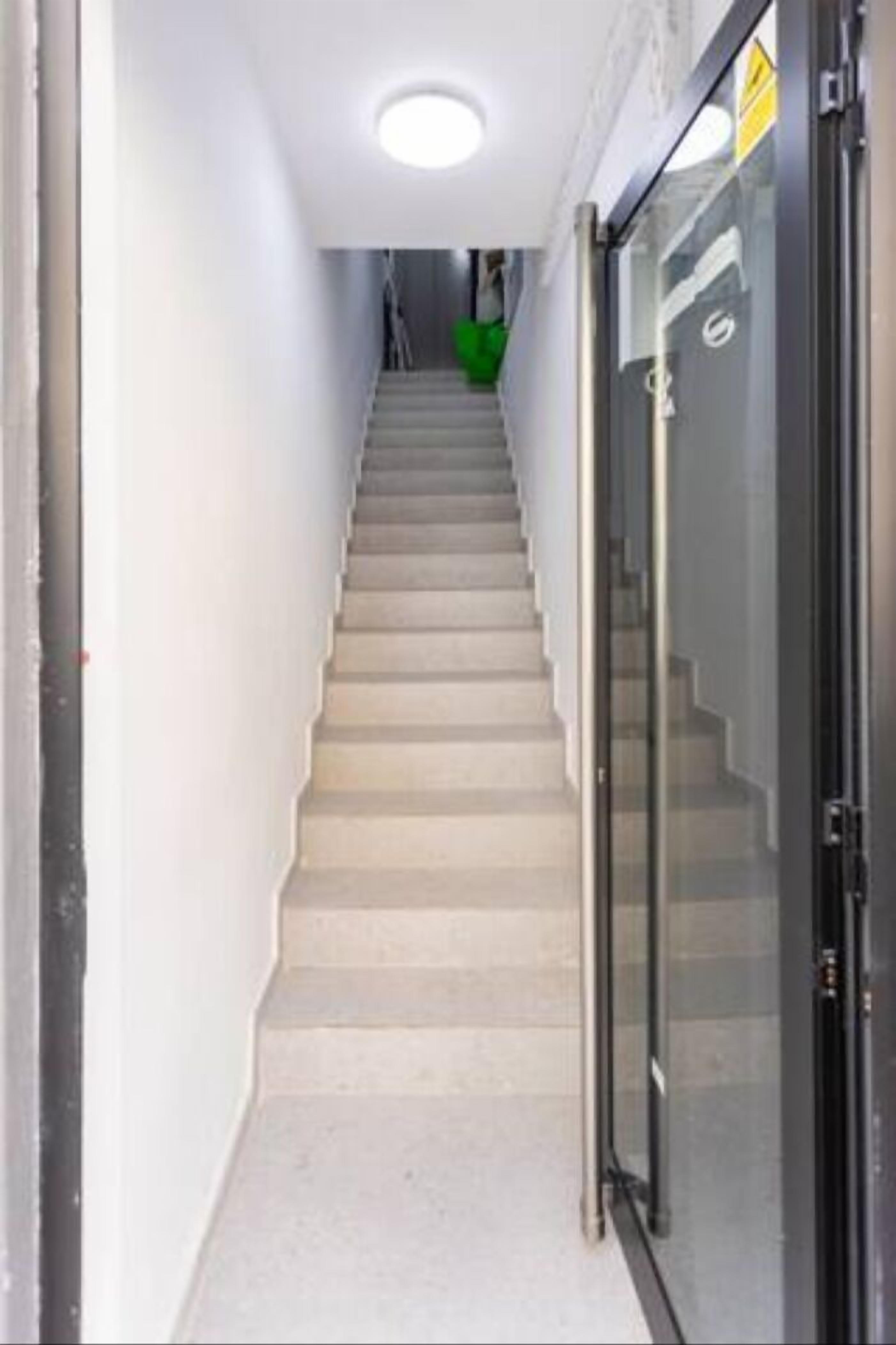 A staircase leading to an upper floor with a glass door on the right.