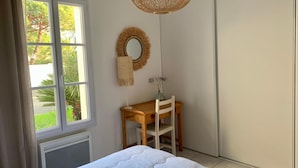 A bedroom with a bed, a desk, a chair, a round mirror, and a hanging light fixture. - AURORE (30 chemin des Burons, n°15, Le Bois Plage) (Le Bois-Plage-en-Ré)