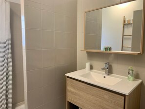 A bathroom with a white sink, a mirror, and a shower curtain.