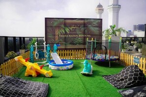 A rooftop play area with a slide, swings, and a ball pit. - Vasaka Maison Bandung (Sumur Bandung)