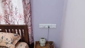 Un dormitorio con cama, mesita de noche y alfombra.