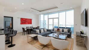 Un salon moderne comprenant un canapé d’angle, une table basse et un coin repas avec des chaises et une table.