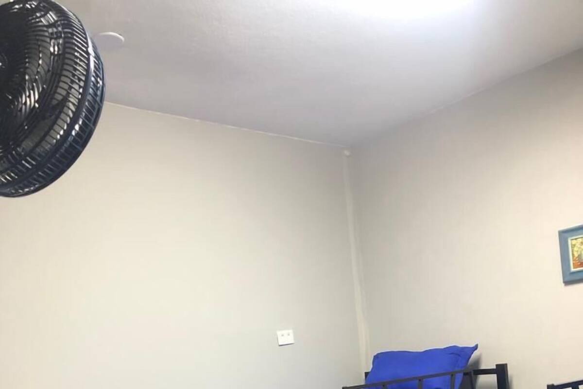 A dormitory room with two bunk beds, each with blue bedding.