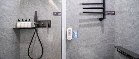 A modern bathroom with a shower, toilet, and hand sanitizer dispenser.
