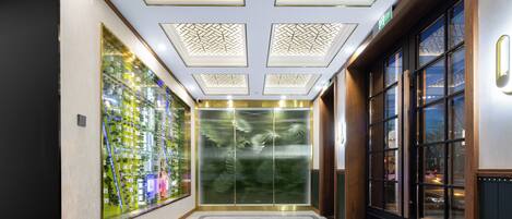 A modern elevator with a glass door and a digital display.