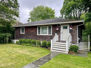 A single-story house with a front porch, a small front yard, and a driveway.
