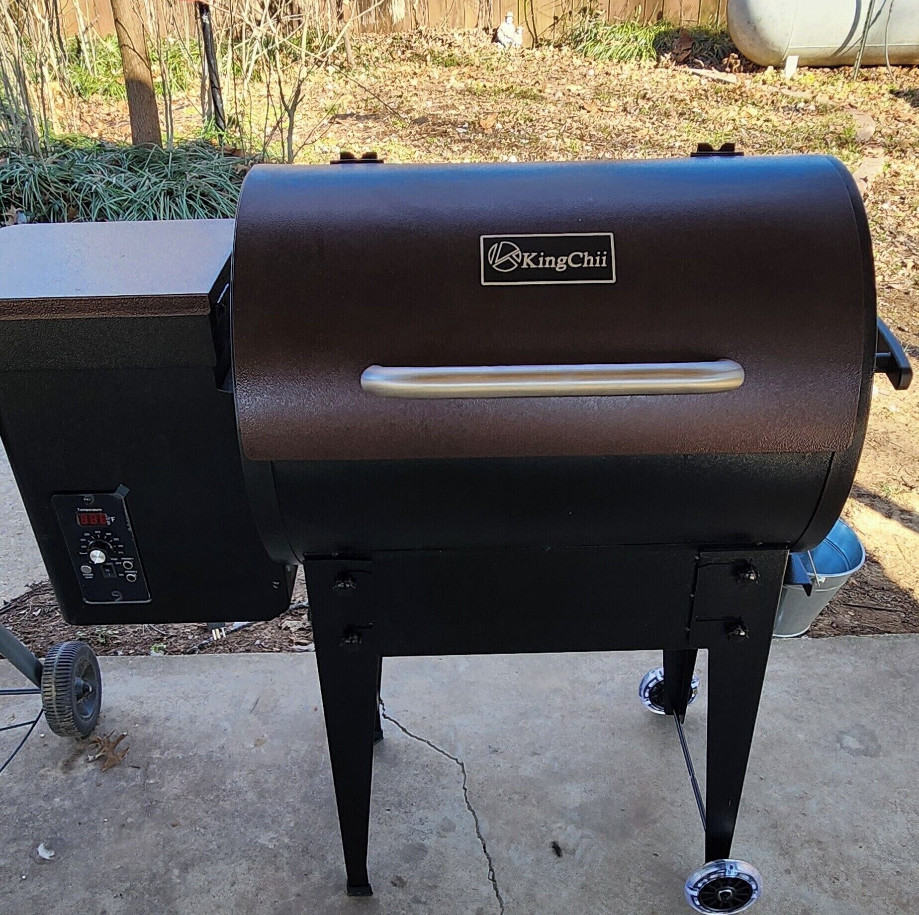 A KingChii barbecue grill with a digital temperature display, a control panel, and a handle.
