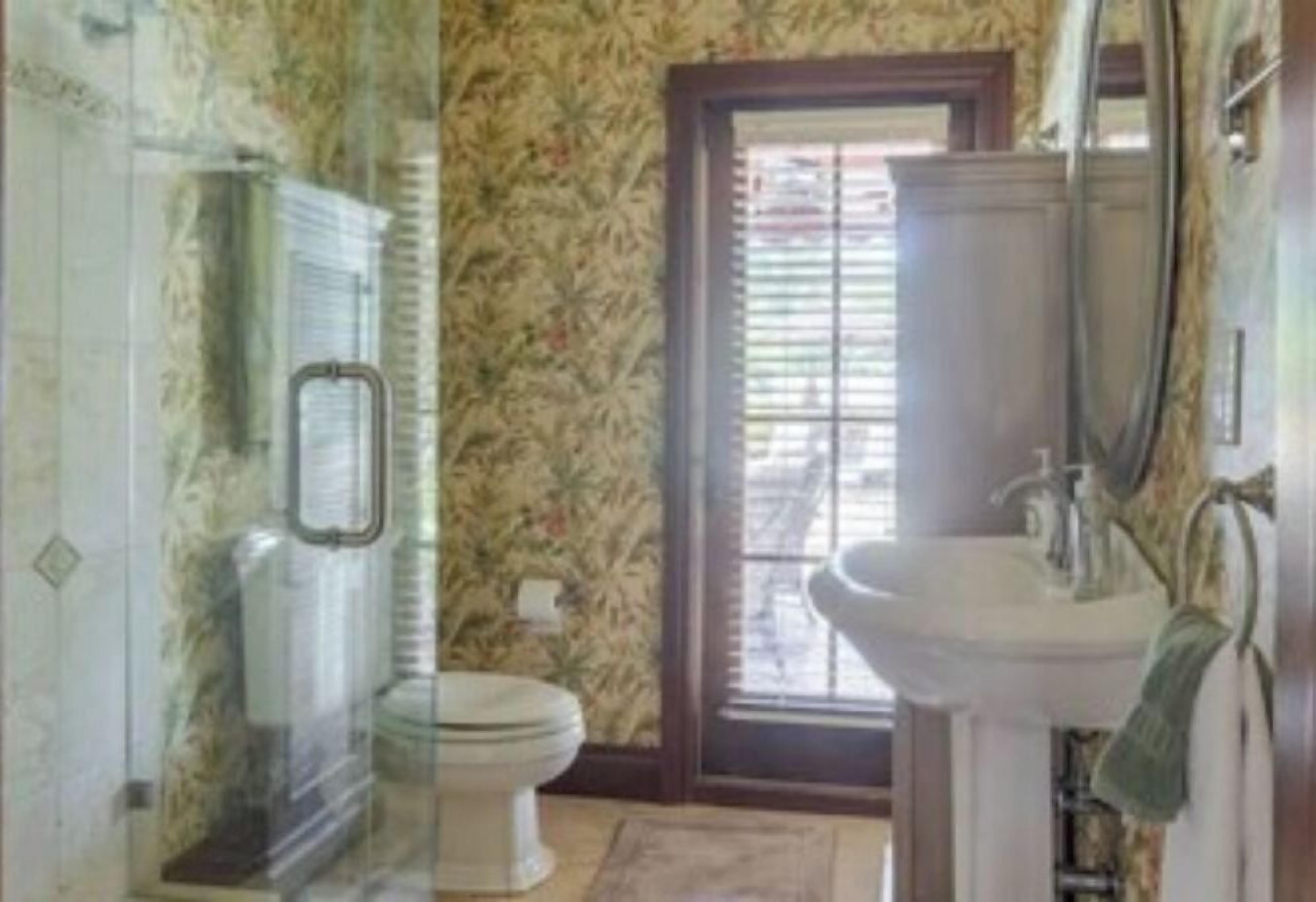 Une salle de bain avec des toilettes, un lavabo et une douche.