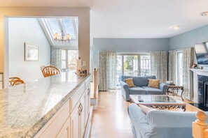 A spacious living area with a kitchen, a dining area, and a fireplace.