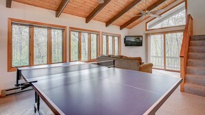 A ping pong table in a room with large windows, wooden beams, and a staircase. - Ski Chalet|Ping-Pong|Fire Pit|5 min -> Slopes 🎿❄️🏂🌲🗻 (Bartlett)