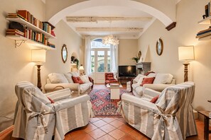 A living room with a fireplace, a television, and a large window. - Casa Clara Luxury with Terrace (Lucca)