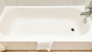 A white bathtub with a single faucet and a drain, set against a tiled wall. - Relax Inn By OYO Sulphur Hwy 90 (Sulphur)