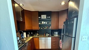 Une cuisine moderne avec des meubles en bois, des appareils en acier inoxydable et un îlot central.