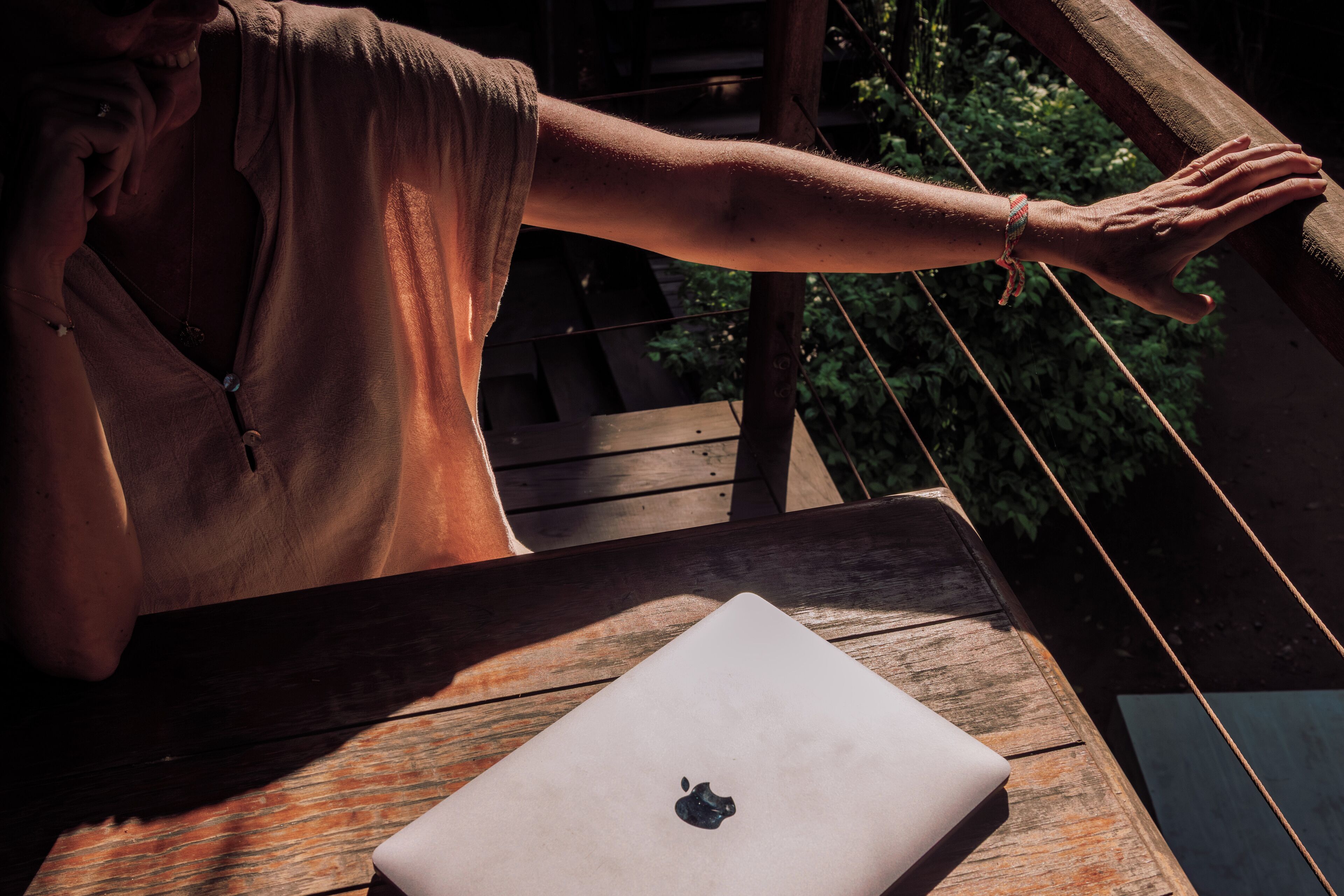 A wooden deck with a laptop on a table.
