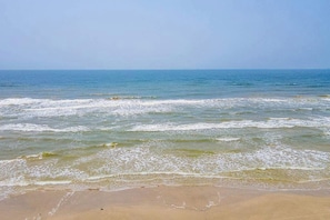 A beach with waves approaching the shore.