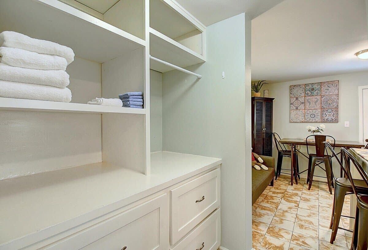 A bathroom with white cabinetry, a sink, and a tiled floor.