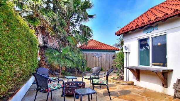 A patio with stone flooring, outdoor furniture, and a wooden fence.