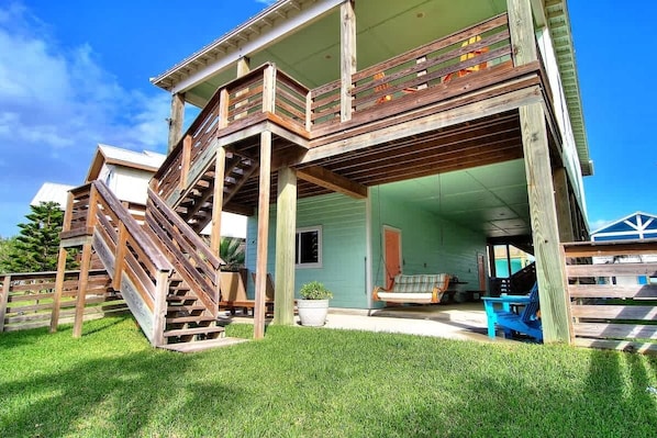 A two-story house with a wooden staircase leading to a balcony.