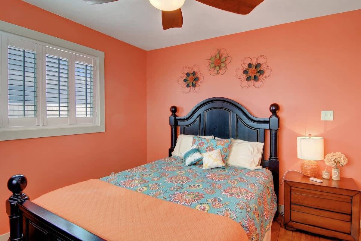 Un dormitorio con cama, mesita de noche y adornos en la pared.