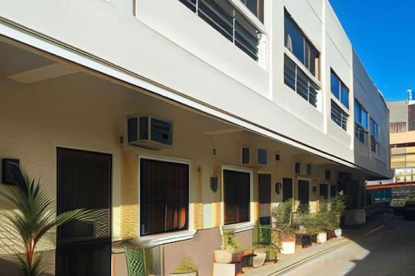 Un bâtiment moderne doté de nombreuses fenêtres et de balcons, caractérisé par une façade plane et un design épuré et minimaliste.