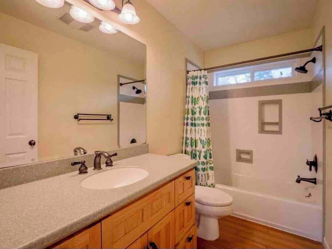 Ein Badezimmer mit doppelter Waschbecken-Anrichte, Toilette, Dusche und Badewanne.