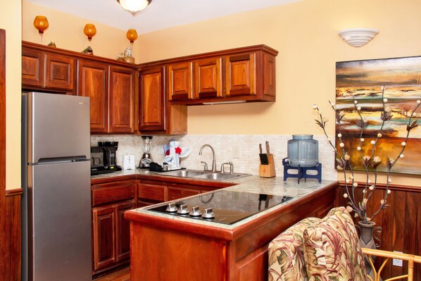 A kitchen with wooden cabinets, a stainless steel refrigerator, a built-in stove, and a coffee maker.