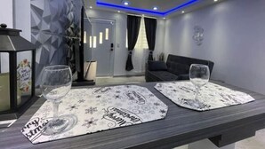 A modern living room with a sofa, a coffee table with placemats, and a decorative wall.