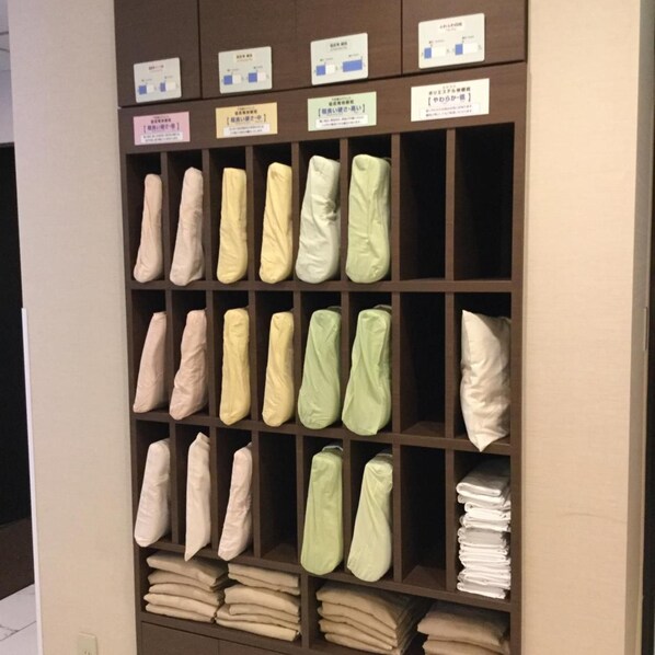 Un depósito con estantes que guardan mantas y almohadas dobladas en varios colores.