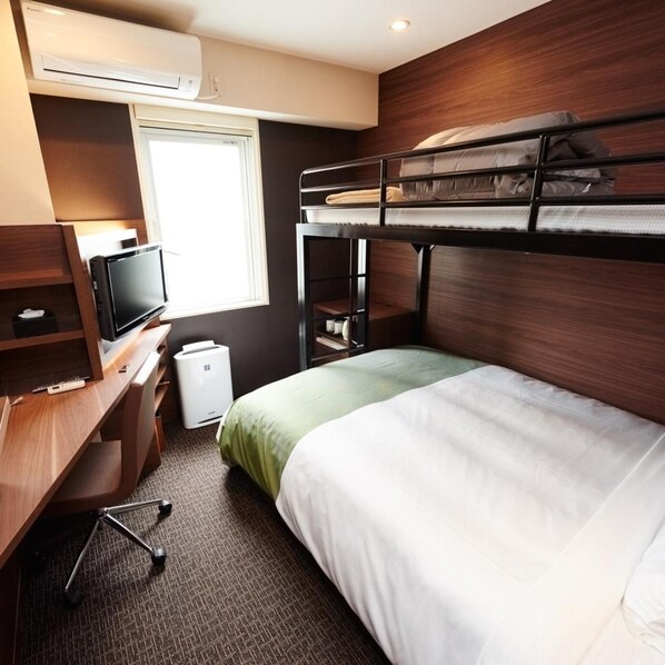 A compact hotel room with a bunk bed, a desk with a television, and a window providing natural light. - Super Hotel Mito Natural Onsen (Mito)