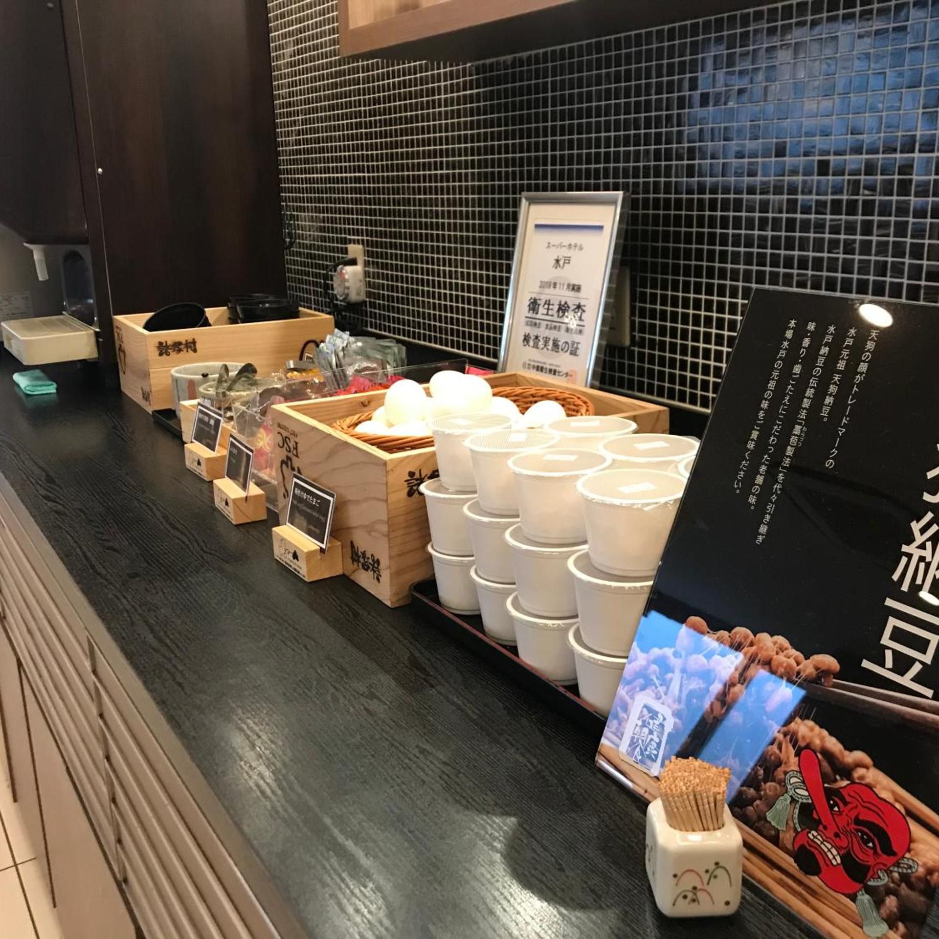 A counter with various items including wooden boxes, white cups, and a display of food items.