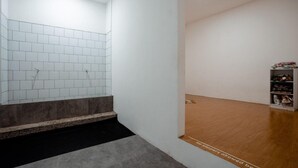 A modern interior with a tiled wall, a wooden floor, and a shoe display. - Bobobox Pods Kota Lama Semarang (Semarang)