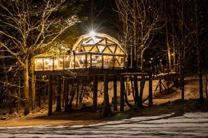 A geodesic dome structure with a viewing platform, surrounded by trees and snow. - Comfortable panoramic dome in the heart of Vercors (Autrans-Méaudre-en-Vercors)