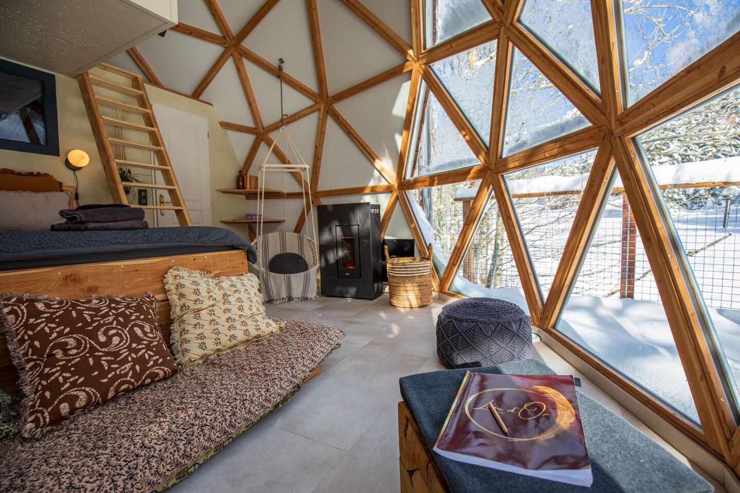 Un intérieur chaleureux avec un plafond en bois, un canapé, un coin lecture et une cheminée.