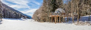 A snow-covered landscape with a wooden cabin structure featuring a dome and a wooden deck. - Comfortable panoramic dome in the heart of Vercors (Autrans-Méaudre-en-Vercors)