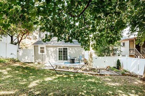 A residential backyard with a patio, a small shed, and a white fence.