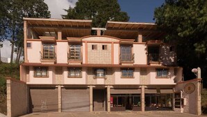 Un edificio de dos pisos con garaje, ventanas grandes y un balcón.