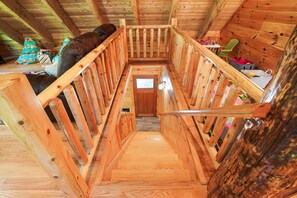 A wooden staircase in a cabin with a view to the outside.