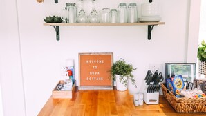 A reception area with wooden shelves displaying various items, a welcome sign, and a wooden counter.