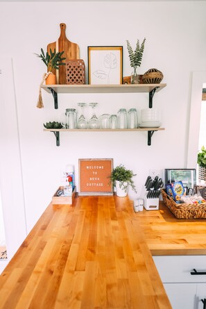 A reception area with wooden shelves displaying various items, a welcome sign, and a wooden counter.