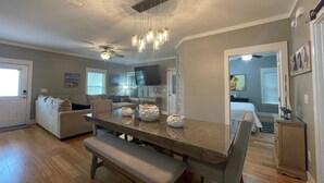 A dining area with a wooden table, bench, and pendant lights. -  PARADISE PALMS 6016 at Rookery III - Walk to Beach - Relax by Pools (Gulf Shores)