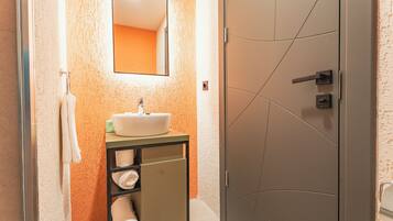 A bathroom with a white sink, a mirror, and a towel rack.