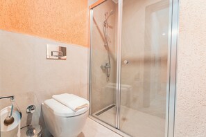 A modern bathroom with a glass-enclosed shower, a toilet, and a towel rack. - Bodrum Local House (Bodrum)