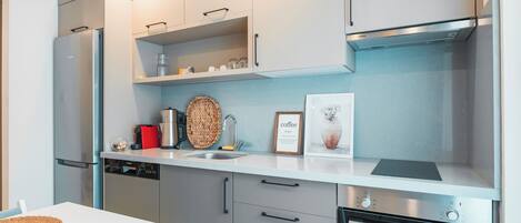 Una cocina moderna con lavavajillas, horno y estación de café.