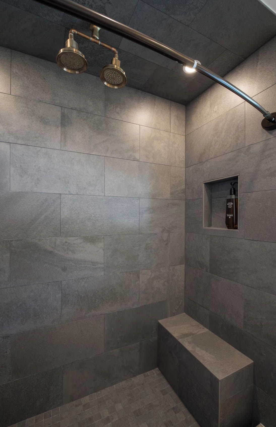 Un espace douche moderne doté d’un banc intégré et d’une douchette à main.