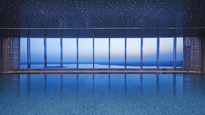 A room with a large window overlooking a body of water and a cityscape, with a starry ceiling. - Hyatt Regency Changshu Kuncheng Lake (Suzhou)