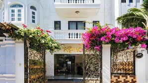 A multi-story building with a central entrance, balconies, and decorative ironwork.