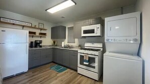 Eine kleine Küche mit Kühlschrank, Mikrowelle, Herd und Backofen.