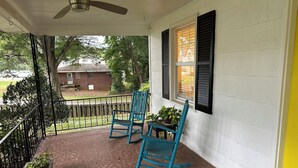 A porch with two rocking chairs, a potted plant, and a window with shutters. - Cozy private efficiency located near downtown Raleigh, PNC Arena, NCSU, RTP, RDU (Raleigh)
