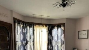 A dining area with a round table, chairs, and a chandelier. - Cozy home away from home.  Located in Steubenville. (Steubenville)