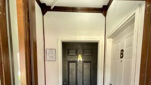 Un couloir avec une porte noire portant l’inscription « A » et une porte blanche portant l’inscription « B ».